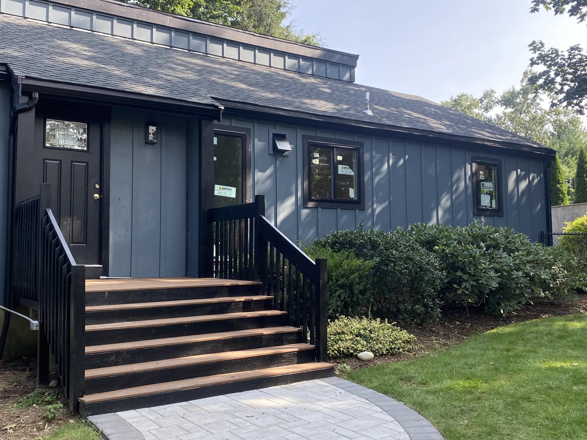 Professional siding installation by Merrimack Valley Roofing in Sandown, NH, featuring dark blue board and batten exterior.