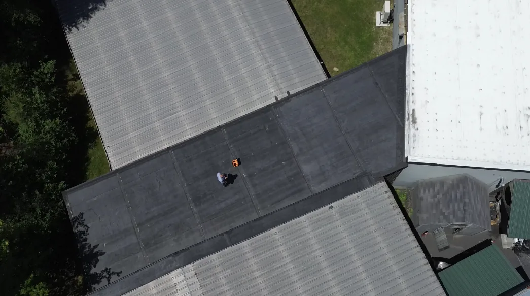 Professional roofing services by Merrimack Valley Roofing in Sandown, NH, featuring a commercial flat roof with EPDM and metal roofing systems.
